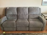 Front view of grey 3-seat sofa with two reclining ends and middle stationary seat
