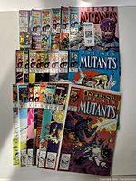 Front view of multiple New Mutants comics stacked together showing colorful covers and titles including issues from 40s series.