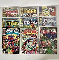 Photo showing front covers of nine Marvel comics including The Thing, Silver Surfer, The Eternals, and Secret Wars