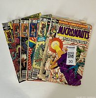 Photo showing the lot of six Micronauts comics fanned out, highlighting varied cover conditions including wear, creases, and spine damage.