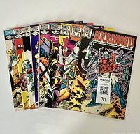 Photo of nine comic books from The Micronauts series with colorful illustrated covers showing characters in sci-fi, robotic and action scenes. Issues include 37, 43, 44, 47, 48, 49 and others, arranged fan-like.