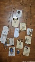 Overview of all jewelry items including necklaces, brooches, and clip earrings displayed on wooden surface with original Edgar Berebi tags.
