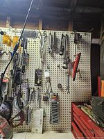Overall view of pegboard with hand tools, including pliers, cutters, and socket sets.