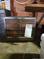 Full view of Cole storage cabinet showing metal frame, wooden drawers with knobs, and Cole logo