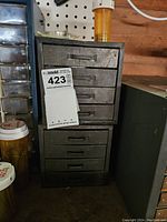 Two stacked vintage metal drawer storage units with four drawers each, showing the overall condition and size