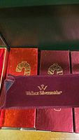 Boxes with velvet covering and candy cane logo, branded Wallace Silversmiths.