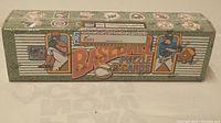 Long rectangular box with green speckled background and baseball player illustrations. "Baseball Puzzle & Cards" printed in large text and multiple MLB team logos present.