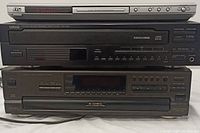 Front view of the 3 stacked devices: silver JVC DVD player on top, black Yamaha CD changer in middle, black Technics 5-disc CD changer on bottom