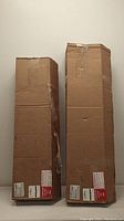 Two sealed cardboard boxes containing window blinds in original factory packaging
