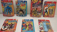 Seven vintage X-Men action figures sealed in original factory packaging, showing front view of packaging with figure and card art visible.