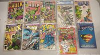 Assortment of comics including The Incredible Hulk, Fantastic Four, Superman, Batman, X-Men, and Betty and Me in protective sleeves on a white surface.