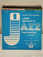 Front cover of a jazz instructional book titled 'A New Approach to Jazz Improvisation' by Jamey Aebersold with blue and white design.