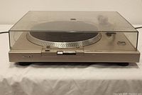 Front view of Sony PS-T20 turntable with closed transparent dust cover showing the body, platter and control buttons.
