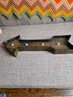 Full view of metal arrow sign showing four working lights mounted along the length.