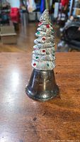 Silver Christmas tree-shaped bell with colored ornaments and 'Christmas 1998' inscription.