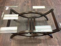 Top down angle showing full glass top and dark wood base with oval midsection design.