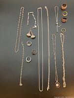 Overview of all chains, earrings, rings, bracelet and pendant necklaces on dark background