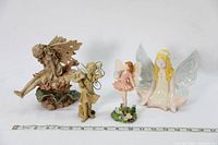 Four fairy figurines displayed with white background, showing various poses and wing styles