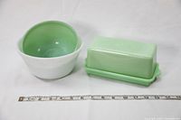 Set of two bowls (one white, one jadeite green) and jadeite covered butter dish with ruler for scale.