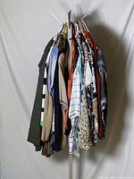Side view of rack of assorted ladies casual and workwear tops in various colors and patterns on hangers