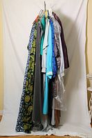 Front view of rack showing all eight vintage garments on hangers against white backdrop