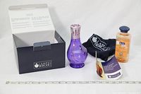 Lot contents including purple glass fragrance lamp, top, oil bottle, pouch, booklet, and box displayed together with ruler for size reference.