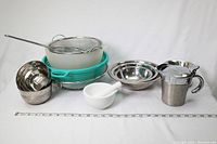 Photo showing the entire lot including strainers, bowls, ceramic mortar and pestle, and gravy cups.