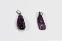 Two polished purple amethyst pendants with silver-tone metal bails for necklaces