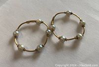 Pair of vintage 10K gold hoop earrings with pearls on each hoop, showing the overall design and clasp