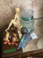Full view of all items: nude resin statue, Roger Rabbit figures, two glass ashtrays, and a fish soapstone carving.