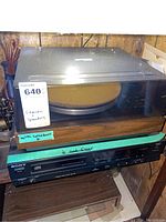 BSR McDonald turntable with dust cover on top, Sony CD player beneath it on the shelf, cables visible to the side