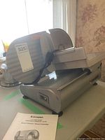 Meat slicer angled view with manual in front