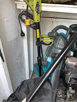 Yardworks leaf blower and partially visible trimmers inside garden shed.