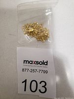 Photo of the 18k gold plated necklace chain inside a small plastic bag with a MaxSold tag beneath.