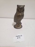 Front view of the brass owl figurine showing detailed feathering and facial features.