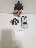 Photo showing three kids toys: Dragon Ball Z figure, robot figure, and toy car.