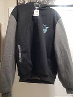 Front view of the black and gray hoodie sweater with small wolf head design on front chest.