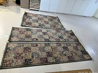Set of one area rug and two runners laid on floor showing size and pattern.