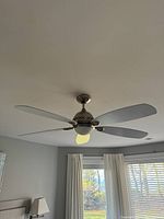 Installed ceiling fan showing 5 white blades and central light from below.