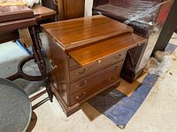 4 drawer wooden side table showing pull out shelf extended and glass top.