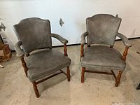 Pair of grey leather office chairs with solid wood frames placed side by side showing front and side views.