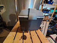 Front view of the gray Koolatron cooler showing its compact rectangular shape and lid with centered latch.