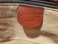 Tag inside the bag indicating the material as genuine leather and made in Florence, Italy.
