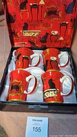 Four bone china teacups with black cat and ornate furniture design in a fitted box with satin lining.