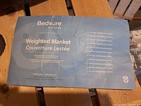Close up of the info sheet of the weighted blanket showing brand Bedsure and product details.
