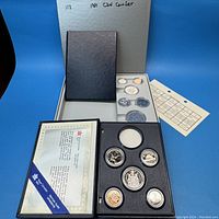 Display of both 1981 and 1987 Canadian coin sets in protective cases with certification and checklist paper included.