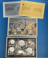 Photo showing two sets of Canadian proof coins from 1985 and 1986 with official Royal Canadian Mint information inserts above the sets.