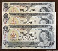 Front view of all three Canadian one dollar notes showing consecutive serial numbers.