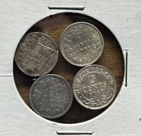 Top view of four silver 5 cent coins in white paper holder, clearly showing dates 1889, 1890, 1901 and 1940 Newfoundland.