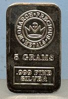 Close-up front photo of the 5 gram Monarch Precious Metals silver bar showing logo, weight and purity stamps.